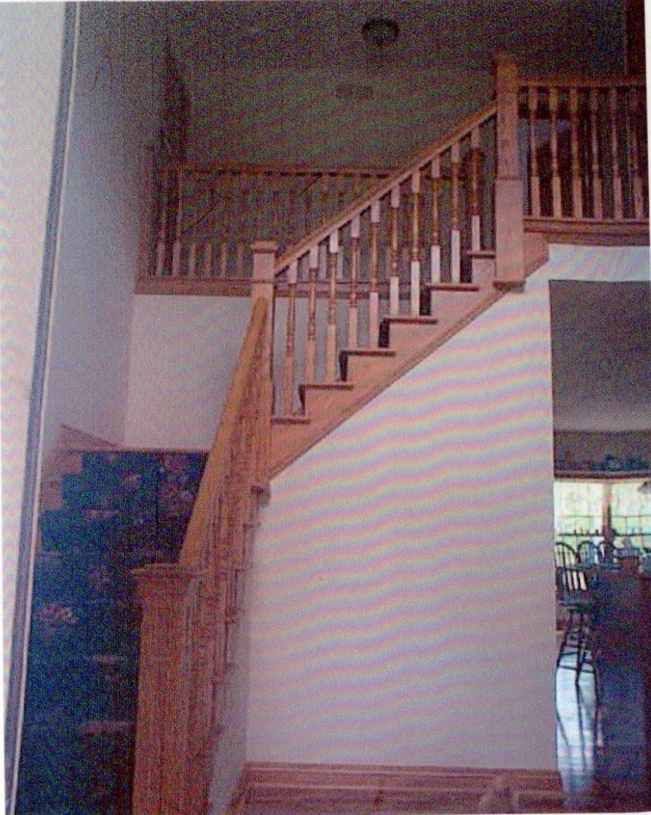 Family home stairwell before the 2016 fire — intact oak railings and carpeted steps